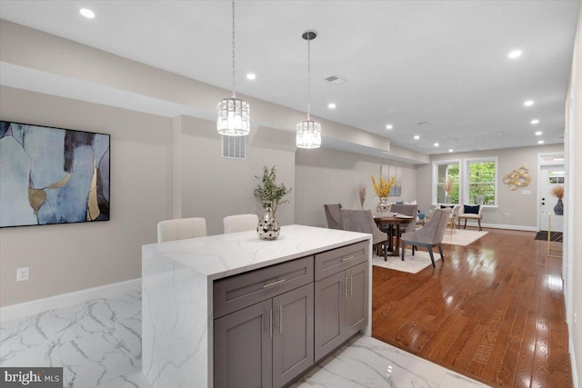 5521 4th St NW, Washington, DC 20011 - kitchen with gray cabinets, recessed lighting, light marble finish floors, baseboards, and light stone counters