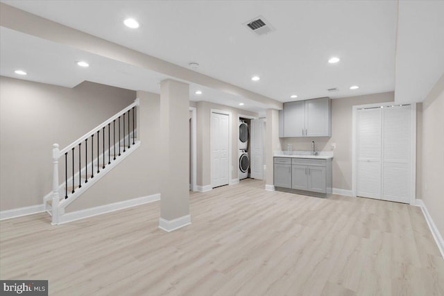 5521 4th St NW, Washington, DC 20011 - unfurnished living room with stacked washer and clothes dryer, stairs, baseboards, light wood-type flooring, and recessed lighting