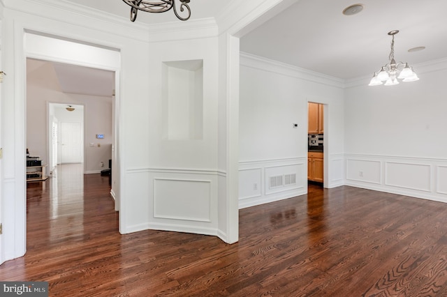 196 Pipers Inn Dr, Fountainville, PA 18923 - unfurnished dining area featuring a chandelier, crown molding, dark wood-style flooring, a wainscoted wall, and a decorative wall