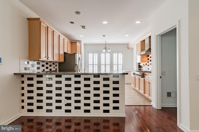 196 Pipers Inn Dr, Fountainville, PA 18923 - kitchen with wall chimney exhaust hood, a peninsula, appliances with stainless steel finishes, a chandelier, and dark wood-style floors