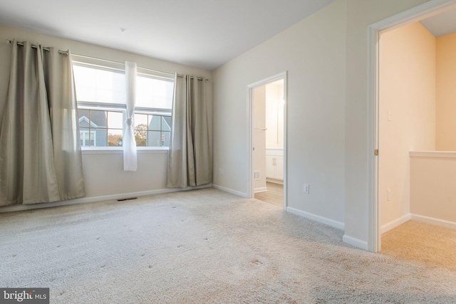 unfurnished bedroom with carpet floors, baseboards, and connected bathroom