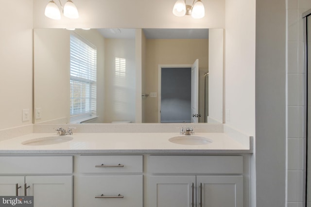 bathroom featuring double vanity and toilet
