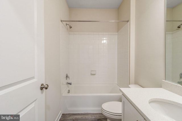bathroom featuring wood finished floors, toilet, vanity, and bathing tub / shower combination