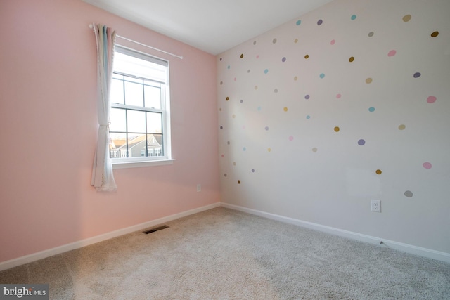 carpeted empty room featuring baseboards