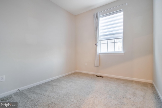 carpeted spare room featuring baseboards