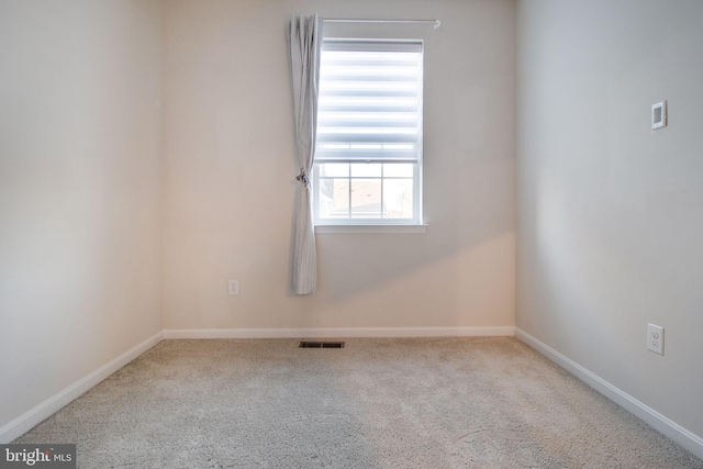 carpeted empty room featuring baseboards