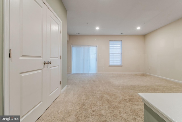 spare room featuring light colored carpet, baseboards, and recessed lighting