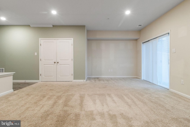 unfurnished living room with recessed lighting, carpet floors, and baseboards