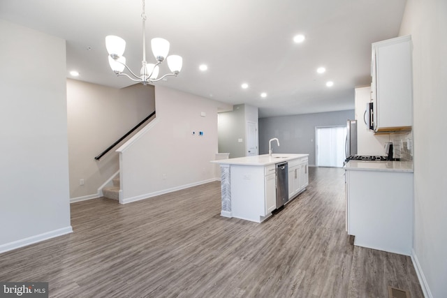kitchen featuring a center island with sink, light wood-type flooring, white cabinets, and recessed lighting