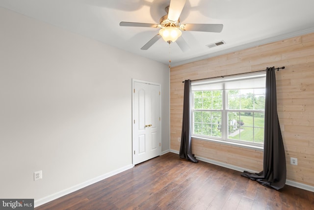 111 Carnoustie, Stephens City, VA 22655 - unfurnished room featuring wood walls, baseboards, dark wood-style flooring, and a ceiling fan