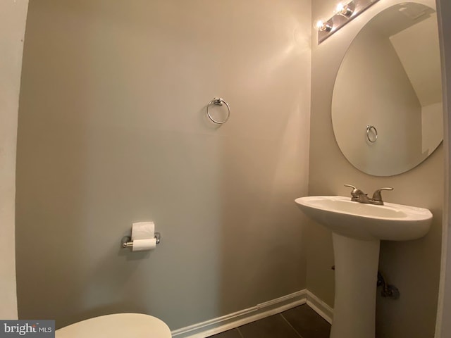 12625 Kempston Ln, Woodbridge, VA 22192 - half bath featuring tile patterned flooring, toilet, baseboards, and a sink