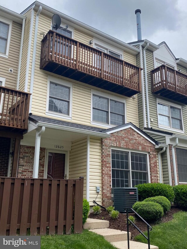 12625 Kempston Ln, Woodbridge, VA 22192 - townhome / multi-family property with a balcony, central AC unit, and brick siding