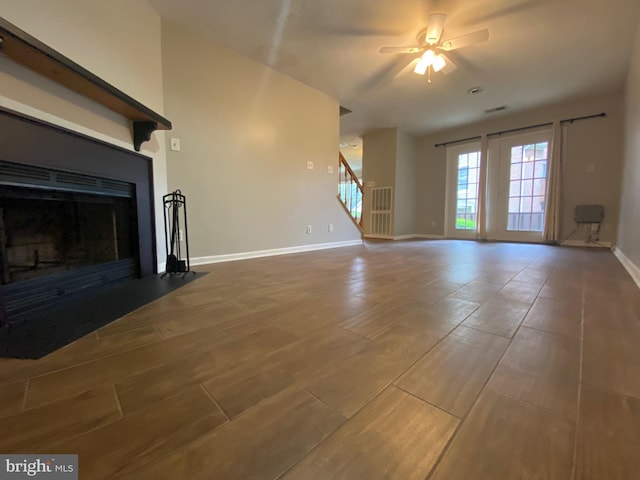 12625 Kempston Ln, Woodbridge, VA 22192 - unfurnished living room featuring a fireplace with flush hearth, baseboards, stairway, wood finished floors, and a ceiling fan
