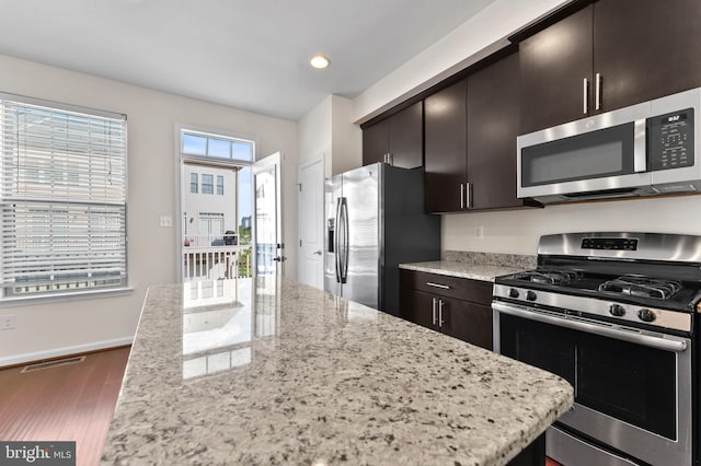 kitchen with stainless steel appliances, dark wood-style flooring, light stone counters, baseboards, and recessed lighting