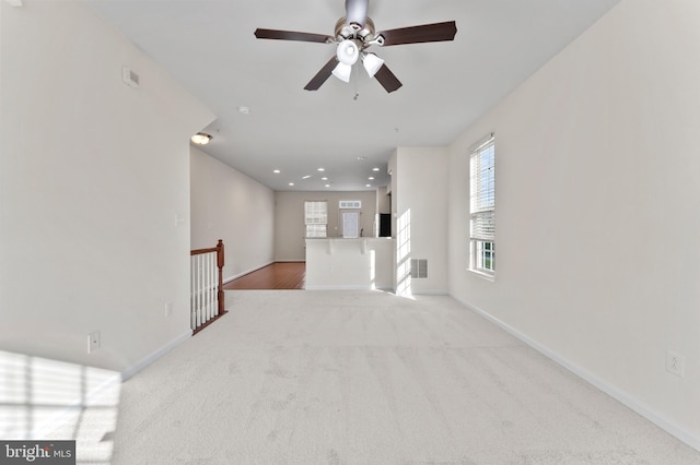 unfurnished living room featuring healthy amount of natural light, a ceiling fan, carpet floors, baseboards, and recessed lighting
