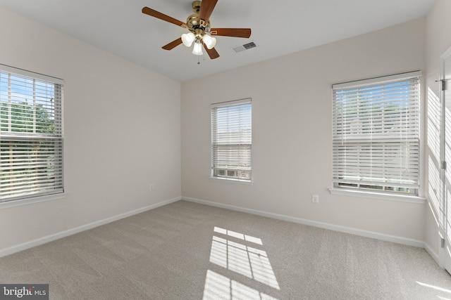 empty room with carpet flooring, a ceiling fan, and baseboards
