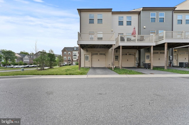 view of front of property featuring a garage, cooling unit, driveway, and a residential view