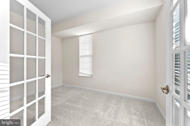 carpeted spare room with french doors and baseboards