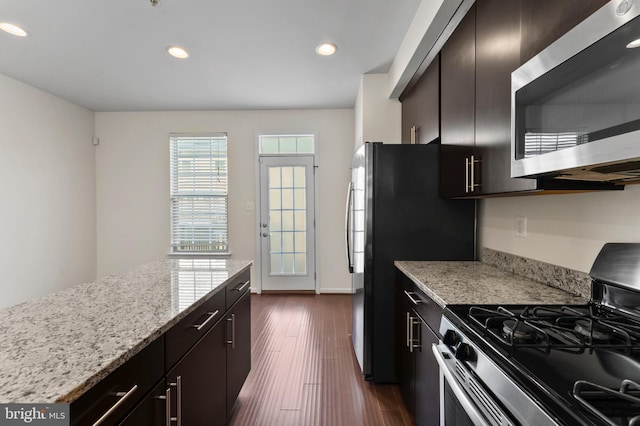 kitchen with stainless steel appliances, recessed lighting, dark wood finished floors, and light stone counters