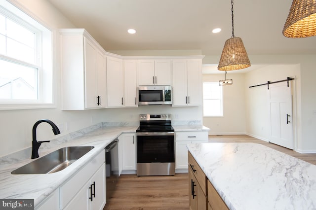 203 N First St, Greenwood, DE 19950 - kitchen featuring stainless steel appliances, a sink, light wood finished floors, recessed lighting, and white cabinetry