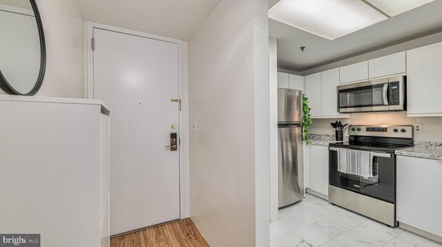 3101 Boardwalk Unit 1206-2, Atlantic City, NJ 08401 - kitchen with stainless steel appliances, white cabinets, light marble finish flooring, and light stone counters
