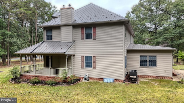 30751 Al Jan Dr, Laurel, DE 19956 - back of house with metal roof, a lawn, covered porch, a chimney, and central AC