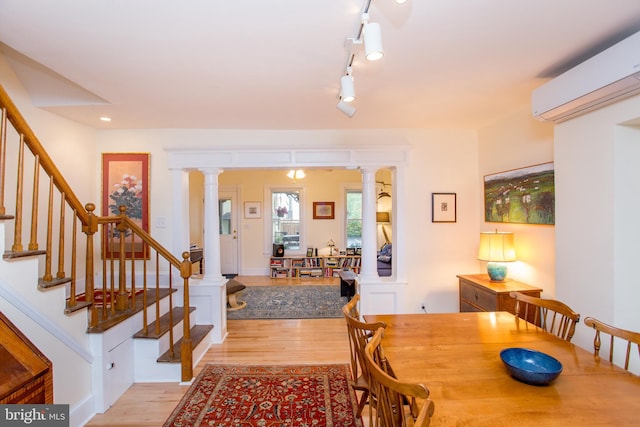 256 N Union St, Lambertville, NJ 08530 - dining space with light wood-style floors, a wall mounted air conditioner, ornate columns, stairs, and recessed lighting