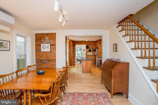256 N Union St, Lambertville, NJ 08530 - dining area featuring light wood finished floors, stairway, a wall unit AC, brick wall, and baseboards