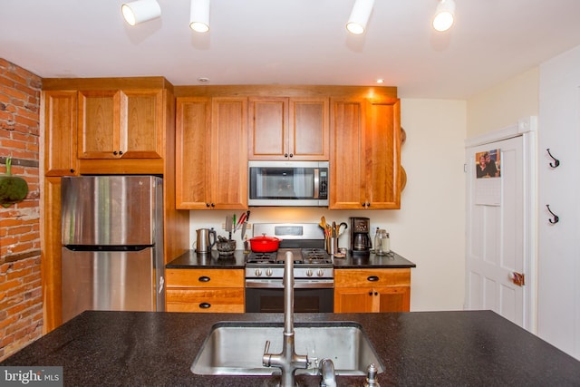 256 N Union St, Lambertville, NJ 08530 - kitchen featuring appliances with stainless steel finishes, dark countertops, brick wall, and brown cabinetry