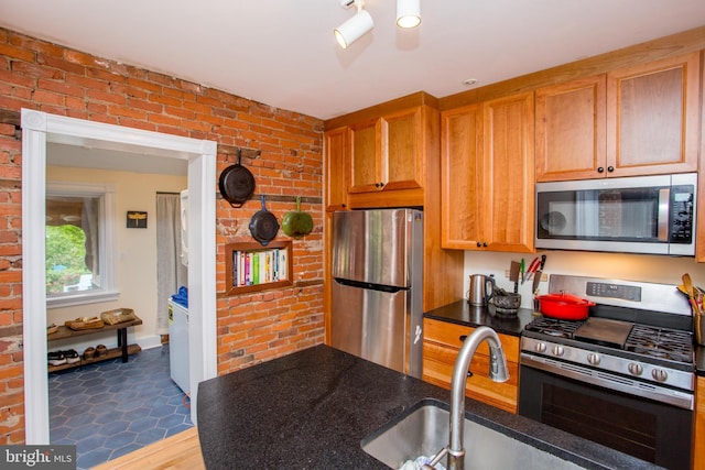 256 N Union St, Lambertville, NJ 08530 - kitchen with stainless steel appliances, brick wall, brown cabinets, and a sink