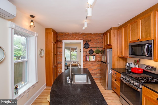 256 N Union St, Lambertville, NJ 08530 - kitchen featuring appliances with stainless steel finishes, a sink, a wall unit AC, brick wall, and light wood-type flooring