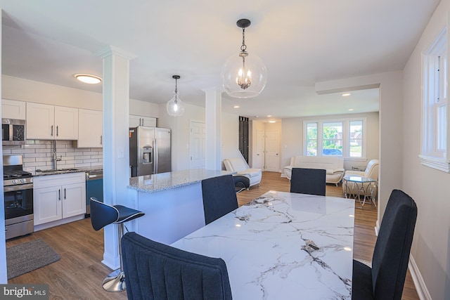 3958 Oakford Ave, Baltimore, MD 21215 - dining room featuring decorative columns and dark wood finished floors