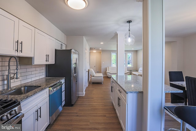 3958 Oakford Ave, Baltimore, MD 21215 - kitchen featuring appliances with stainless steel finishes, dark wood-type flooring, white cabinetry, backsplash, and stone countertops