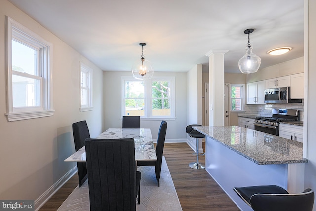 3958 Oakford Ave, Baltimore, MD 21215 - dining room with plenty of natural light, dark wood-style flooring, and decorative columns