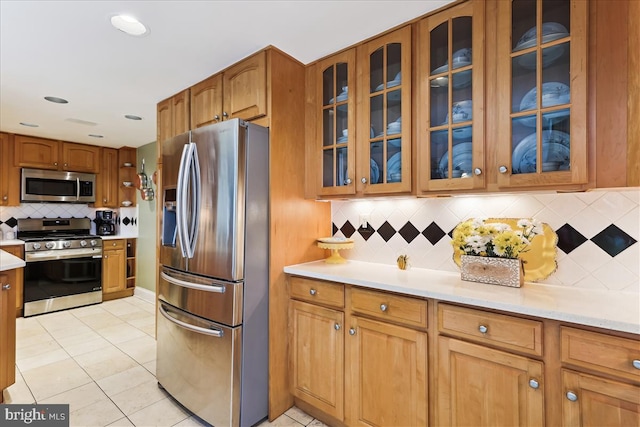 430 M St SW Unit N-609, Washington, DC 20024 - kitchen with stainless steel appliances, backsplash, light countertops, and light tile patterned flooring