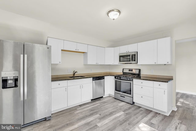 414 Lavender Hill Dr, Cherry Hill, NJ 08003 - kitchen with appliances with stainless steel finishes, a sink, dark countertops, and light wood-style floors