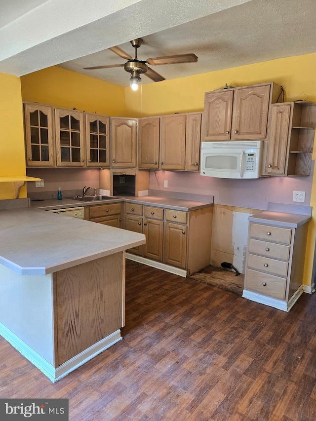 kitchen featuring white microwave, a peninsula, dark wood-style floors, glass insert cabinets, and a ceiling fan