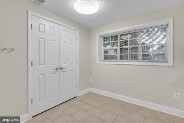 1458 Blockton Ct, Crofton, MD 21114 - unfurnished bedroom with multiple windows, baseboards, a closet, and light tile patterned floors