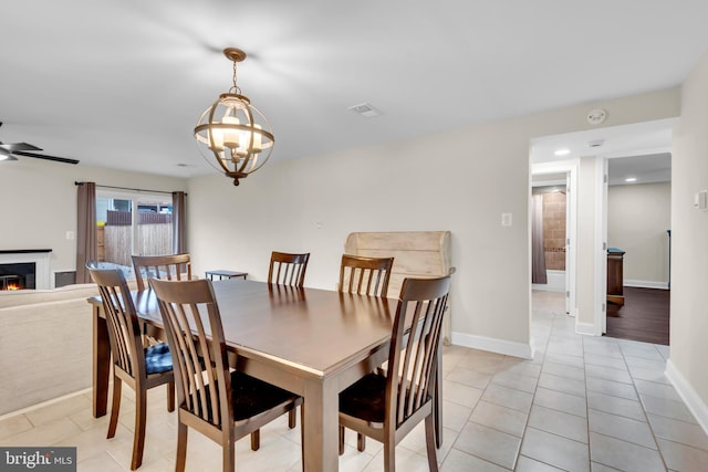1458 Blockton Ct, Crofton, MD 21114 - dining room with baseboards, a lit fireplace, light tile patterned floors, a chandelier, and ceiling fan
