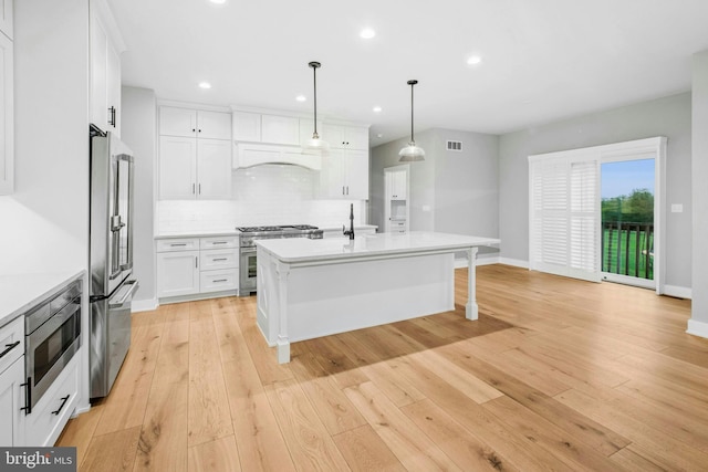 385 Nolf Rd, Nazareth, PA 18064 - kitchen featuring premium appliances, light countertops, backsplash, a kitchen breakfast bar, and white cabinetry