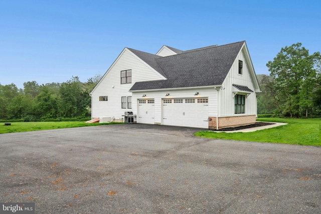 385 Nolf Rd, Nazareth, PA 18064 - view of home's exterior with board and batten siding, asphalt driveway, a yard, roof with shingles, and a garage