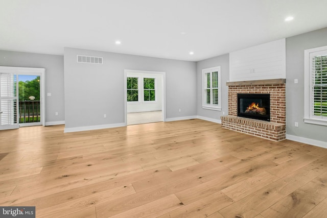 385 Nolf Rd, Nazareth, PA 18064 - unfurnished living room featuring light wood-style floors, a brick fireplace, healthy amount of natural light, recessed lighting, and baseboards