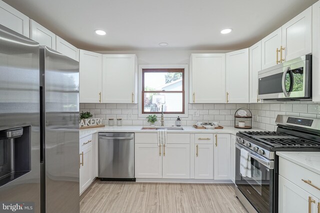 360 N Broad St, Clayton, NJ 08312 - kitchen with stainless steel appliances, a sink, white cabinetry, tasteful backsplash, and light wood-style flooring