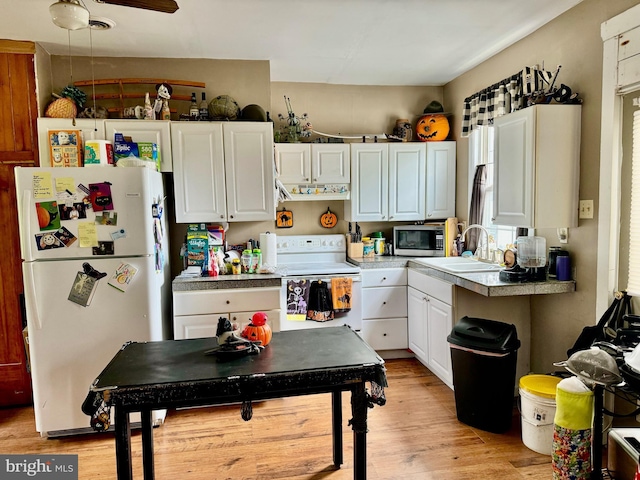 5569 Bouquet St, Huntingdon, PA 16652 - kitchen featuring white appliances, a sink, white cabinets, light wood-style floors, and a ceiling fan