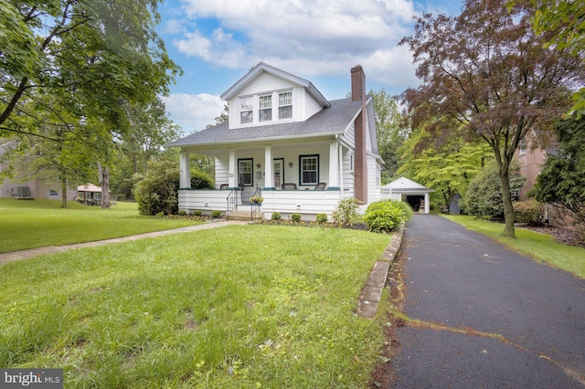 550 Somerton Ave, Philadelphia, PA 19116 - bungalow-style house featuring a chimney, an outbuilding, a porch, a front lawn, and a detached garage