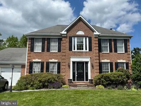 10226 Tarpley Ct, Ellicott City, MD 21042 - view of front of property featuring an attached garage, a front lawn, and brick siding