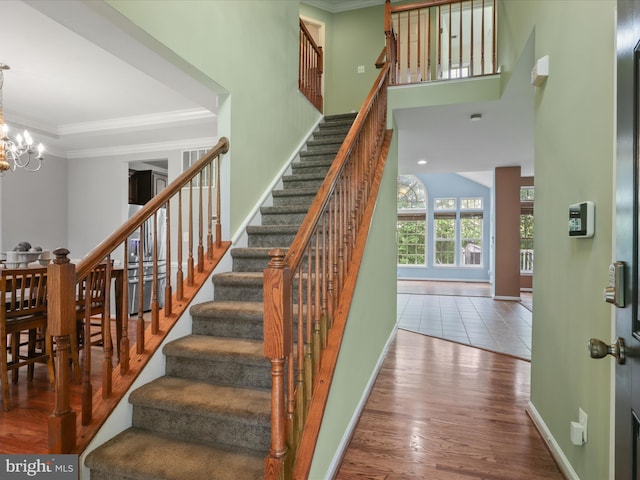 9499 Ballagan Ct, Bristow, VA 20136 - stairway featuring a chandelier, ornamental molding, wood finished floors, and baseboards