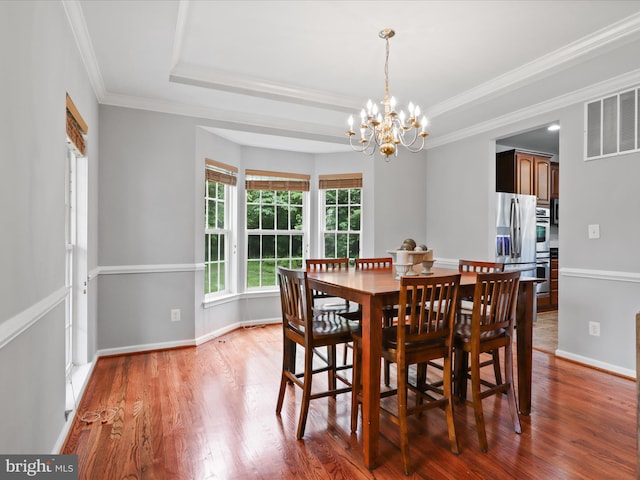 9499 Ballagan Ct, Bristow, VA 20136 - dining space featuring a chandelier, wood finished floors, ornamental molding, a raised ceiling, and baseboards
