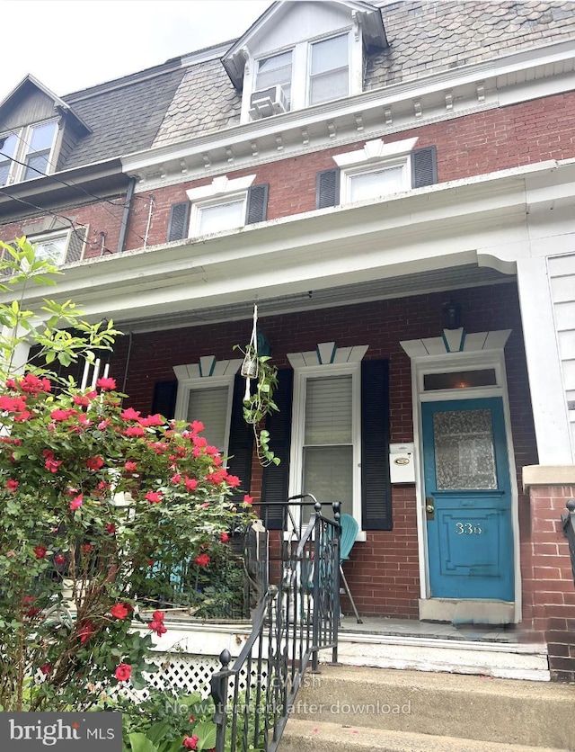 property entrance with mansard roof, covered porch, and a high end roof