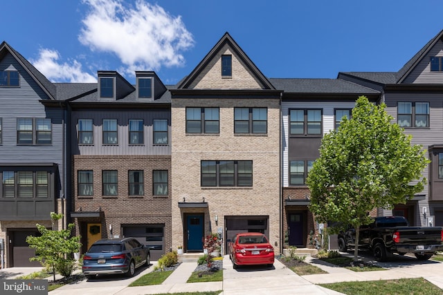multi unit property featuring driveway, a garage, and brick siding